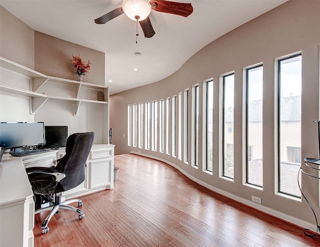 office with light wood-type flooring and ceiling fan