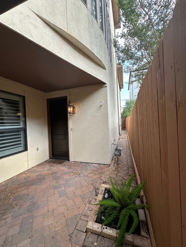 view of exterior entry with a patio area