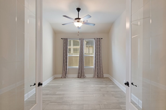 spare room featuring french doors, light wood-type flooring, and ceiling fan