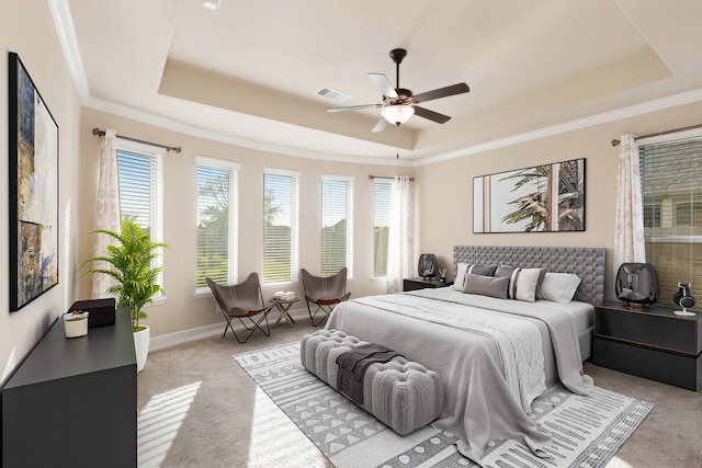 carpeted bedroom featuring a raised ceiling, ceiling fan, and ornamental molding