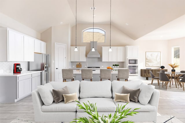 living room featuring light hardwood / wood-style floors and high vaulted ceiling