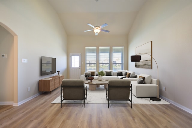 living room featuring ceiling fan, light hardwood / wood-style floors, and high vaulted ceiling