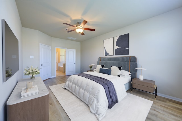 bedroom featuring ceiling fan, light hardwood / wood-style floors, and connected bathroom