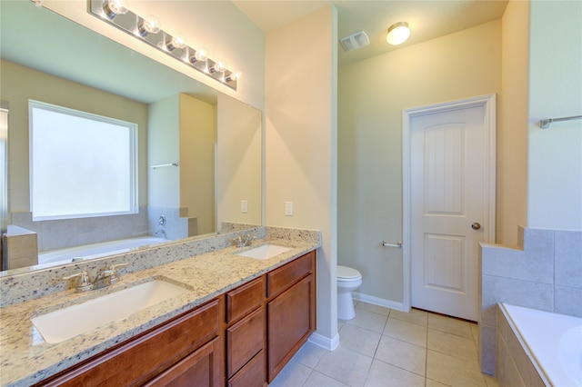 bathroom featuring tile patterned floors, vanity, toilet, and tiled tub