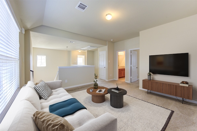 living room featuring light colored carpet and vaulted ceiling