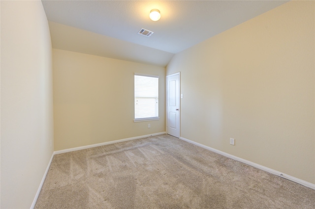 carpeted spare room with vaulted ceiling