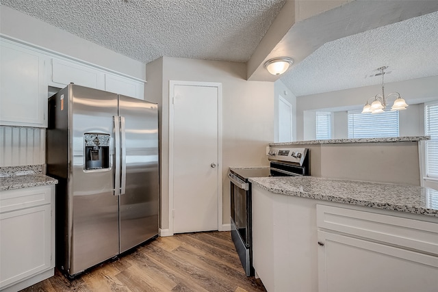 kitchen with white cabinetry, pendant lighting, stainless steel appliances, and light wood-type flooring