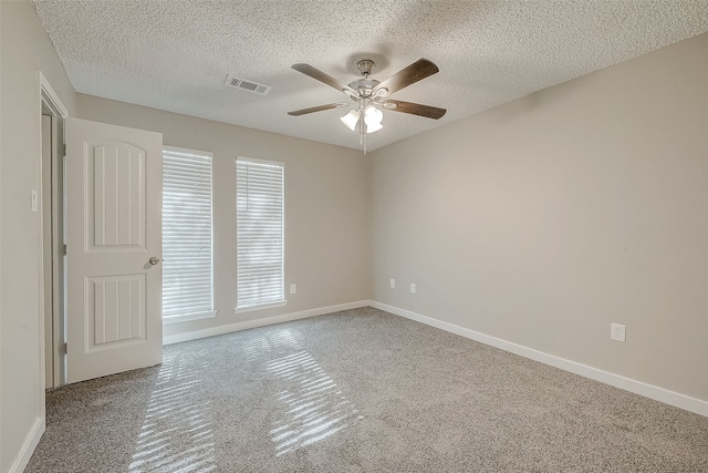 spare room with carpet flooring, ceiling fan, and a textured ceiling