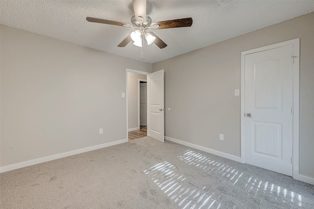 unfurnished bedroom featuring light carpet, a textured ceiling, and ceiling fan