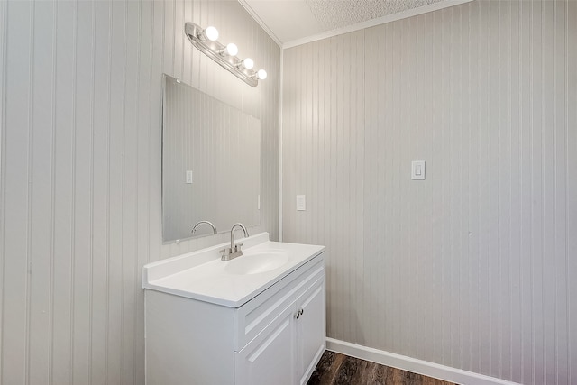 bathroom featuring hardwood / wood-style flooring, vanity, wood walls, and ornamental molding