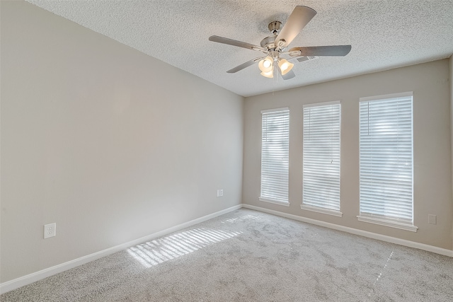 carpeted empty room featuring ceiling fan and a textured ceiling