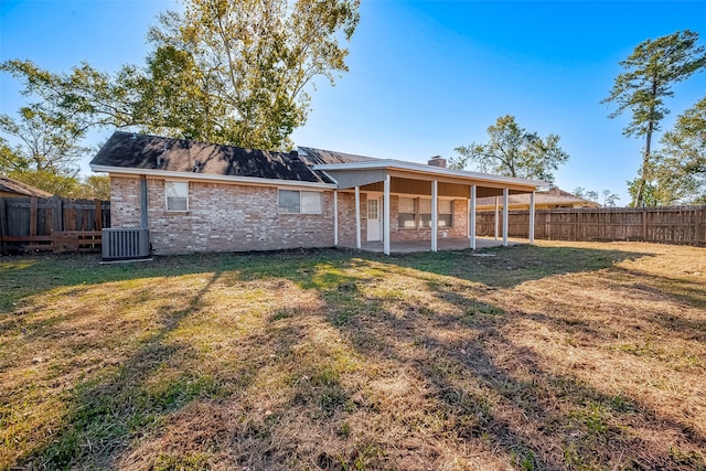 back of house featuring central AC unit, a yard, and a patio