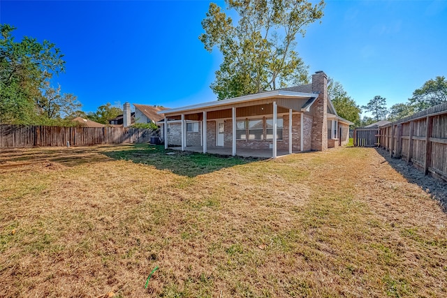 rear view of house featuring a lawn