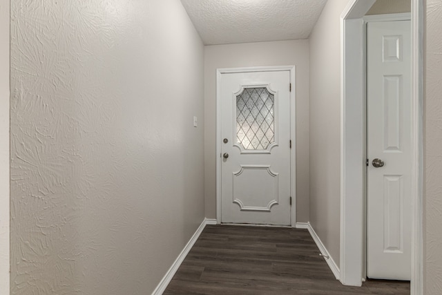 entryway featuring dark wood-type flooring and a textured ceiling