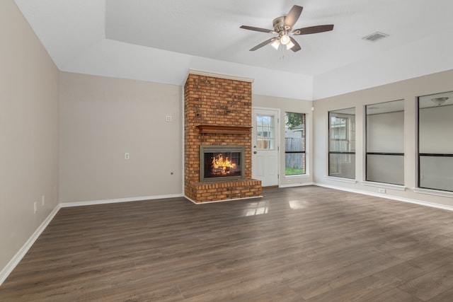 unfurnished living room with ceiling fan, dark wood-type flooring, and a brick fireplace