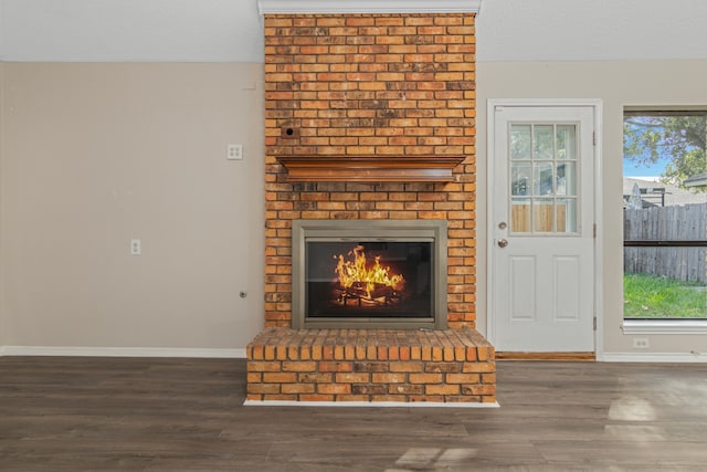 unfurnished living room featuring a fireplace, plenty of natural light, dark wood-type flooring, and a textured ceiling