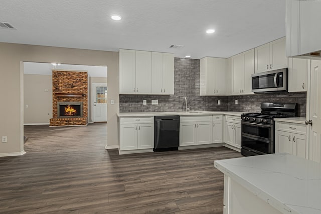 kitchen with white cabinetry, dark wood-type flooring, stainless steel appliances, and sink