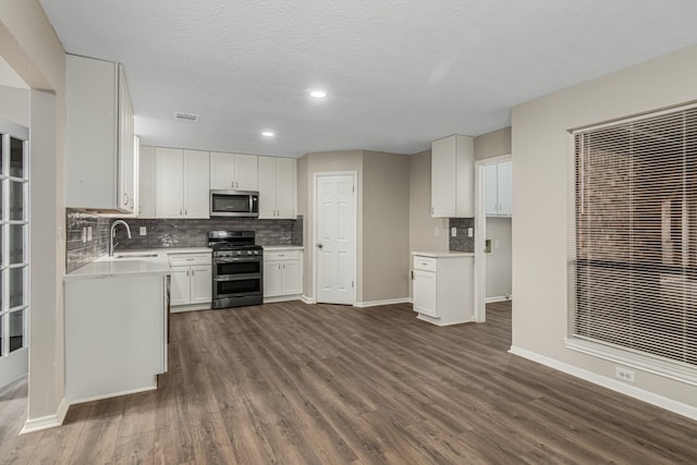 kitchen featuring dark hardwood / wood-style flooring, a textured ceiling, stainless steel appliances, sink, and white cabinetry