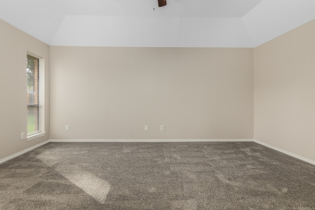 spare room with dark colored carpet, ceiling fan, and lofted ceiling