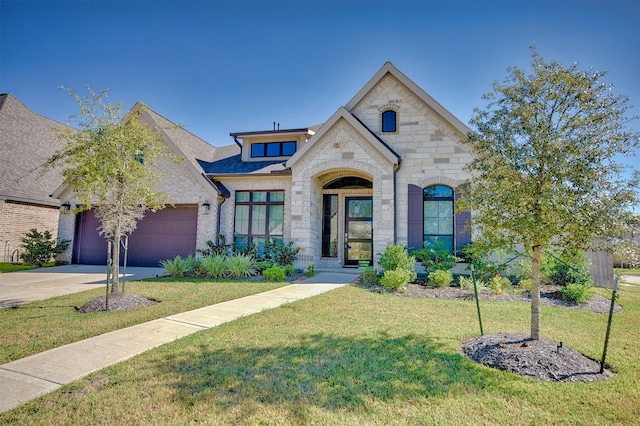 french country style house featuring a front yard and a garage