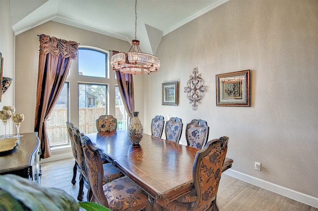 dining space with crown molding, light hardwood / wood-style floors, vaulted ceiling, and a notable chandelier