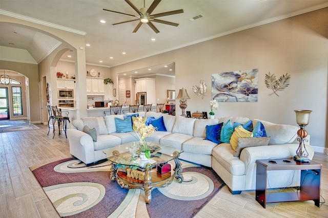 living room featuring ceiling fan, crown molding, and light wood-type flooring