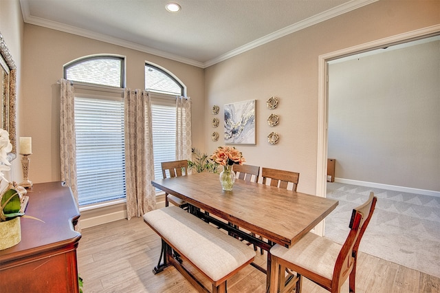 dining area with light hardwood / wood-style floors and crown molding