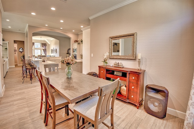 dining space featuring light hardwood / wood-style flooring and ornamental molding