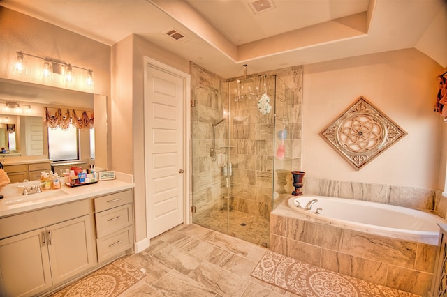 bathroom with a tray ceiling, plus walk in shower, and vanity