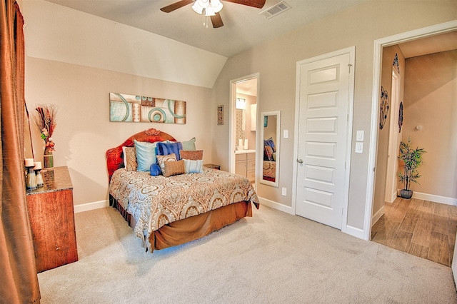 carpeted bedroom with ceiling fan, ensuite bath, and vaulted ceiling