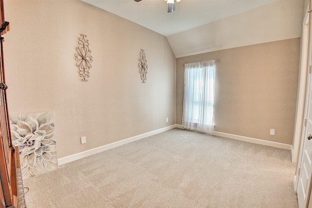 empty room with ceiling fan, light carpet, and vaulted ceiling