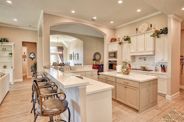 kitchen featuring kitchen peninsula, appliances with stainless steel finishes, a center island, and light hardwood / wood-style floors