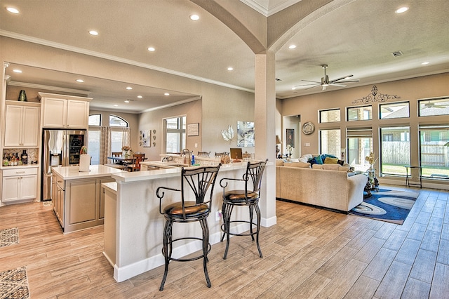 kitchen featuring white cabinetry, plenty of natural light, and a breakfast bar area