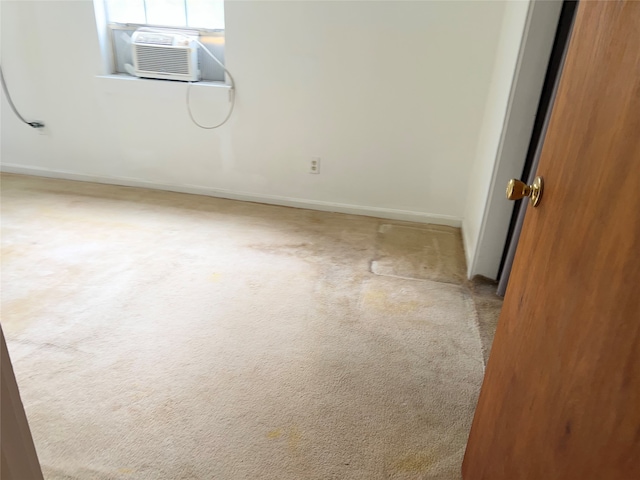 unfurnished room featuring light carpet and cooling unit