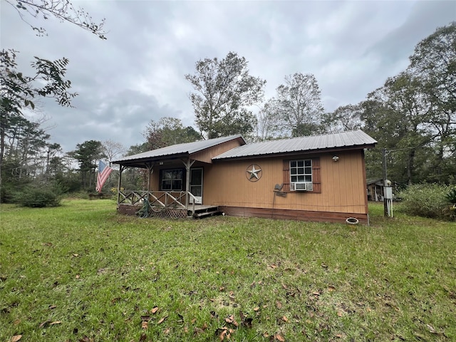 back of house featuring a lawn and covered porch