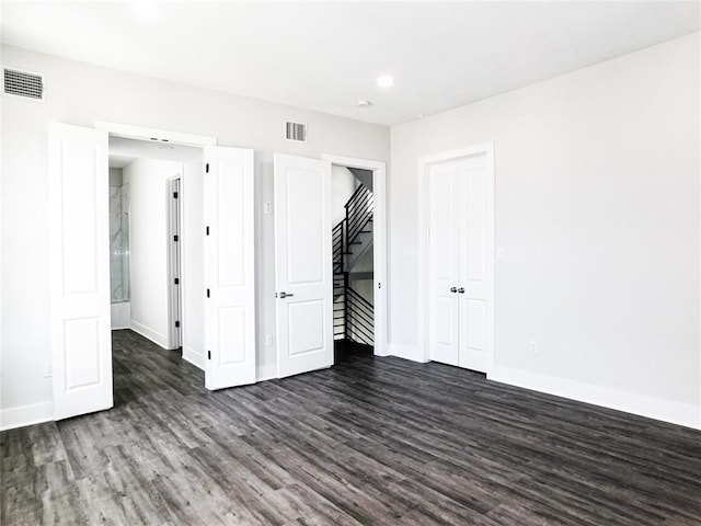 unfurnished bedroom with dark hardwood / wood-style flooring