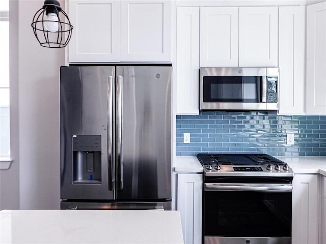 kitchen with white cabinets, appliances with stainless steel finishes, and tasteful backsplash