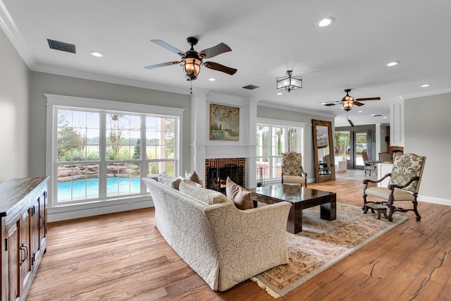 living room featuring ceiling fan, plenty of natural light, and light hardwood / wood-style flooring