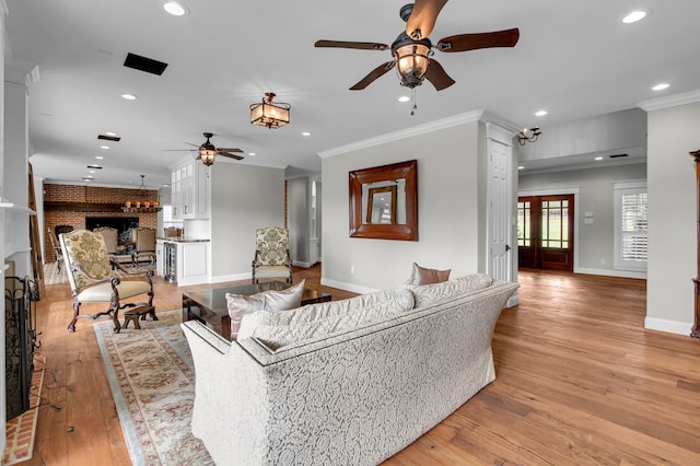 living room featuring crown molding, ceiling fan, and light hardwood / wood-style floors