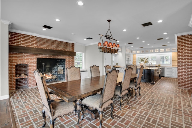 dining area featuring a fireplace, brick wall, and ornamental molding