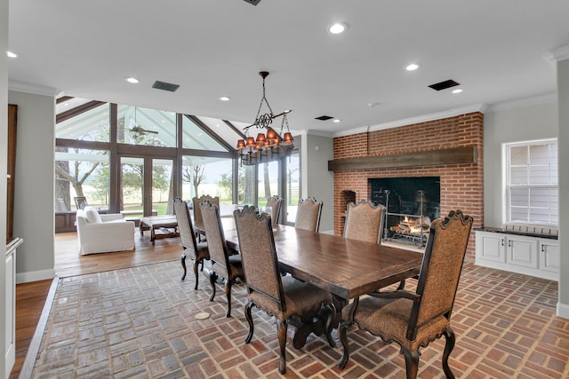 dining space featuring crown molding, a wall of windows, a fireplace, and a chandelier