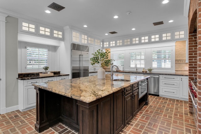 kitchen featuring white cabinetry, sink, stainless steel appliances, and dark brown cabinets