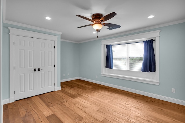 unfurnished bedroom with a closet, ceiling fan, crown molding, and light hardwood / wood-style floors