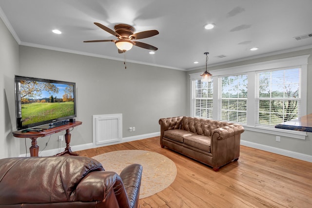 living room with light hardwood / wood-style flooring, ceiling fan, and crown molding