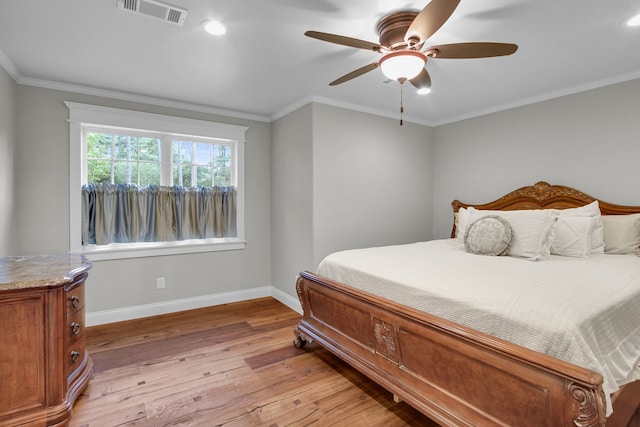 bedroom featuring light hardwood / wood-style floors, ceiling fan, and ornamental molding