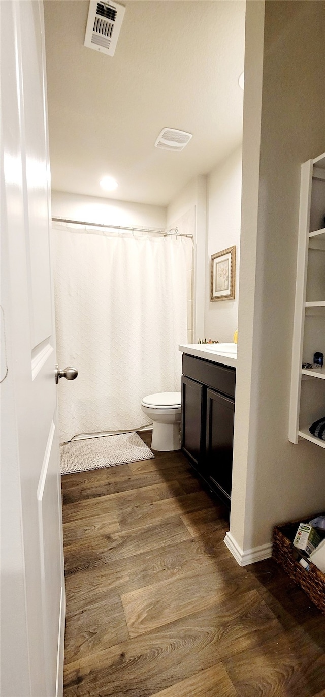 bathroom with hardwood / wood-style flooring, vanity, toilet, and a shower with shower curtain