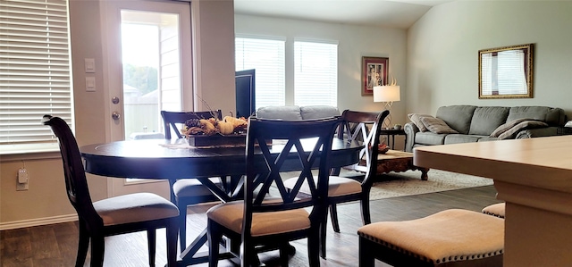 dining area featuring dark wood-type flooring and lofted ceiling