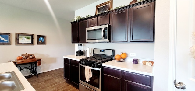 kitchen with dark hardwood / wood-style flooring, dark brown cabinets, stainless steel appliances, and sink