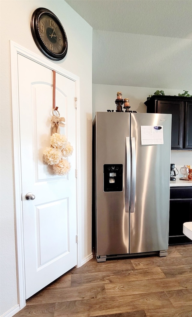 kitchen featuring stainless steel fridge with ice dispenser and light hardwood / wood-style flooring