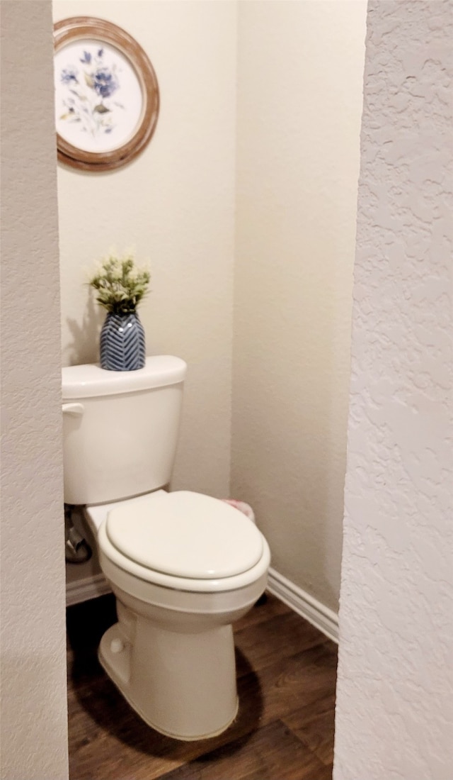 bathroom featuring toilet and wood-type flooring